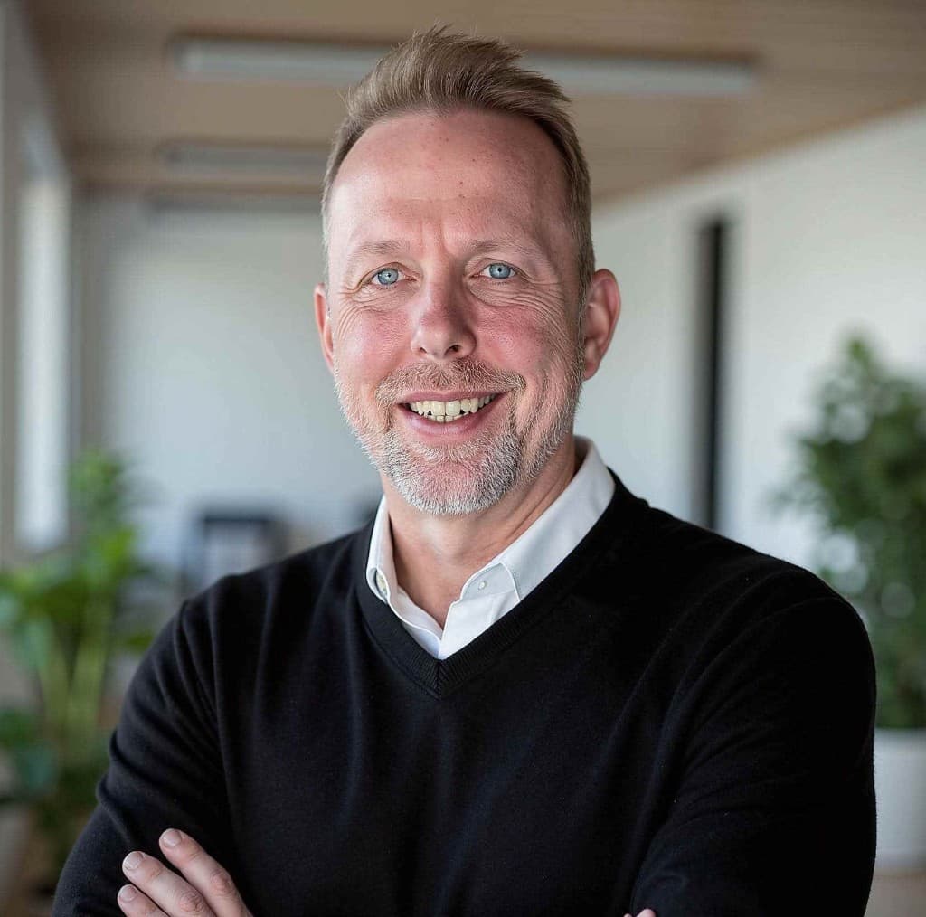Portrait of Robert Vogt, founder of FlexLeague+, in business casual attire, smiling in a bright office setting